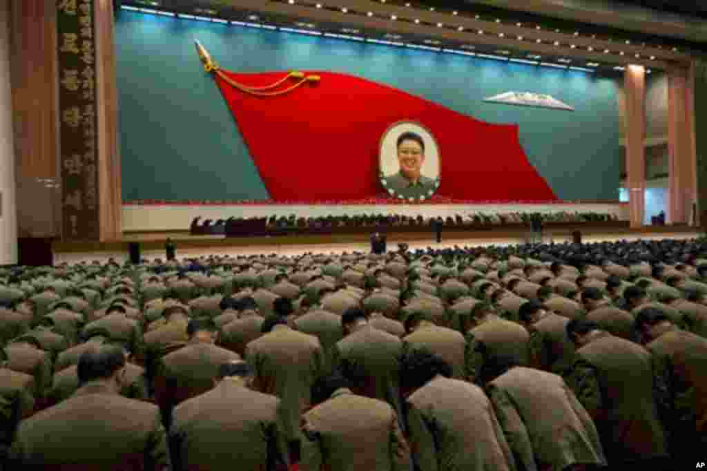 North Korean military officers bow at an image of late North Korean leader Kim Jong Il during a national meeting of top party and military officials on the eve of Kim's first death anniversary in Pyongyang, North Korea, Sunday, Dec. 16, 2012.