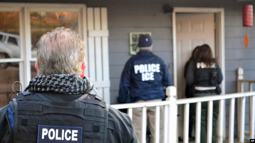 Nhân viên công lực ICE trước một ngôi nhà ở Atlatan, bang Georgia, trong một chiến dịch truy quét di dân bất hợp pháp và những di dân phạm tội hình sự.
