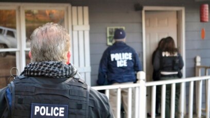 Nhân viên công lực ICE trước một ngôi nhà ở Atlatan, bang Georgia, trong một chiến dịch truy quét di dân bất hợp pháp và những di dân phạm tội hình sự.