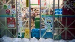 Taped up windows and bags filled with water to counter a flood surge greet last dash shoppers at a convenience store in the Shinagawa district of Tokyo on October 12, 2019, as the effects of Typhoon Hagibis begin to be felt in Japan's capital. (AFP)