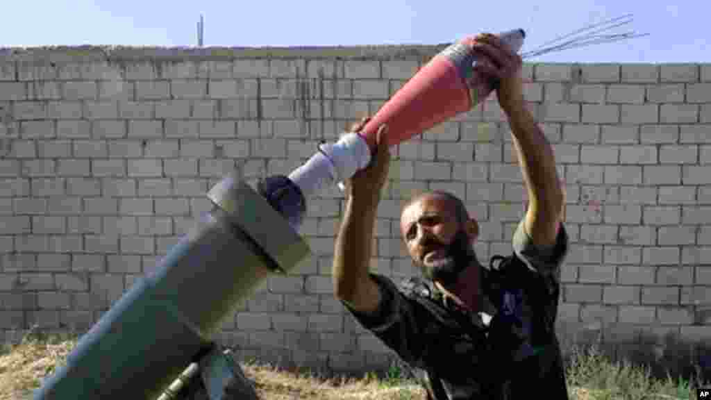 Free Syrian army fighter moments before firing a heavy mortar toward the airport in Aleppo, Syria, Sept. 2, 2013. 