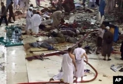 Pilgrims and first responders gather at the site of a crane collapse that killed dozens inside the Grand Mosque in Mecca, Saudi Arabia, Friday, Sept. 11, 2015.