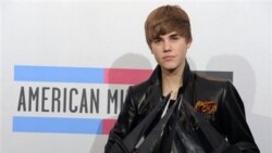 Justin Bieber hold his awards backstage at the 38th Annual American Music Awards on 21 Nov. 2010 in Los Angeles.