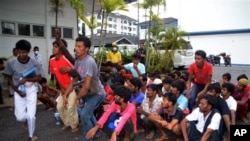 Illegal immigrants from Myanmar and Bangladesh arrive at the Langkawi police station's multi purpose hall in Langkawi, Malaysia on Monday, May 11, 2015. Hundreds of migrants abandoned at sea by smugglers in Southeast Asia have reached land and relative sa