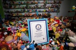 Sertifikat Percival Lugue untuk rekor dunia Guinness untuk koleksi mainan cepat saji terbesar difoto dengan koleksi mainannya di rumahnya di Apalit, Pampanga, Filipina, 20 April 2021. (Foto: REUTERS/Eloisa Lopez)