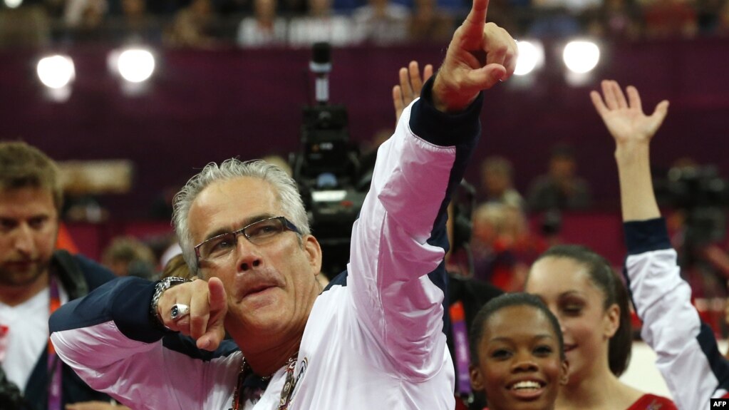 资料照片：在伦敦奥运会上，时为美国奥运女子体操队主教练的戈德尔特和队员们庆祝夺取金牌。(2012年7月31日)(photo:VOA)