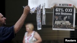 A man looks at newspapers showing the results of yesterday's referendum in central Athens, Greece, July 6, 2015. Greeks overwhelmingly rejected conditions of a rescue package from creditors on Sunday, throwing the future of the country's euro zone members. (REUTERS/Christian Hartmann)