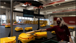 An employee places a parcel on a robot at the Hellenic Post's sorting centre in Kryoneri, Greece, October 4, 2021. Picture taken October 4, 2021. REUTERS/Alkis Konstantinidis