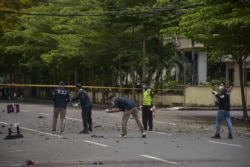 Polisi forensik memeriksa lokasi tersebut setelah diduga bom meledak di dekat sebuah gereja di Makassar pada 28 Maret 2021. (Foto: AFP/Indra Abriyanto)