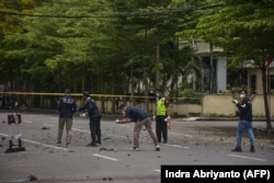 Polisi forensik memeriksa lokasi tersebut setelah diduga bom meledak di dekat sebuah gereja di Makassar pada 28 Maret 2021. (Foto: AFP/Indra Abriyanto)