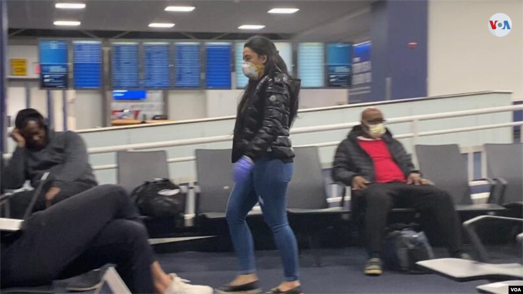 En el aeropuerto de Nueva York esta semana, varios pasajeros protegiendo su nariz y boca con mascarillas. (Foto: Celia Mendoza)