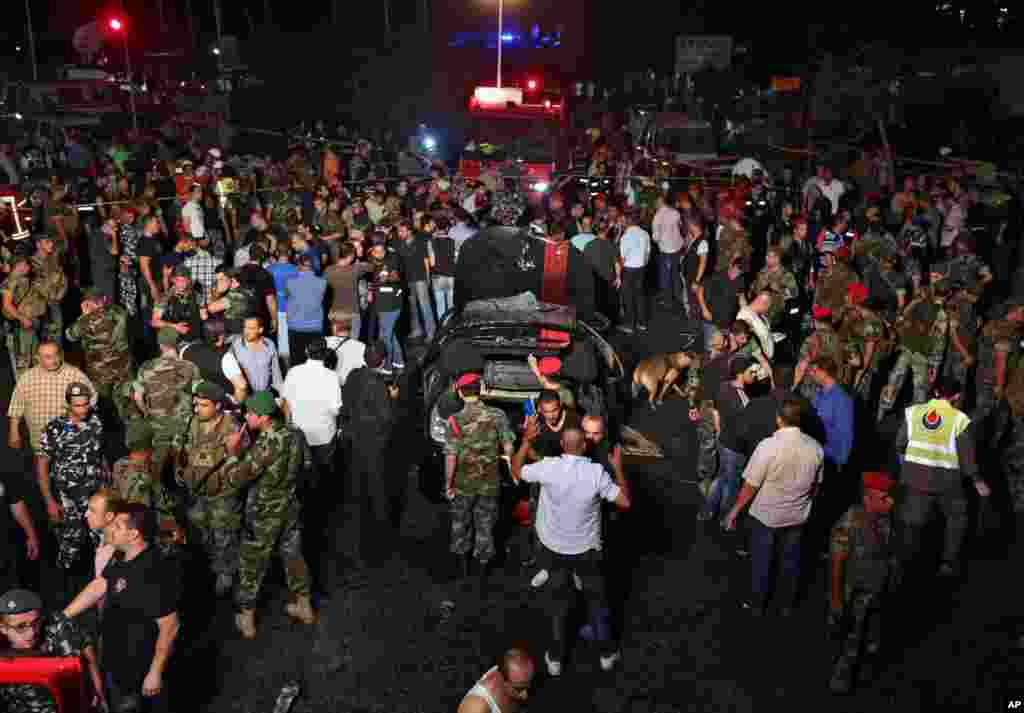 Lebanese soldiers and citizens gather at the site of a car bombing in a southern suburb of Beirut, June 24, 2014. 