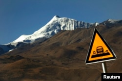 A road sign is seen in front of the Kharola glacier some 200 km (125 miles), west of Lhasa Tibet Autonomous Region, Nov. 25, 2009.