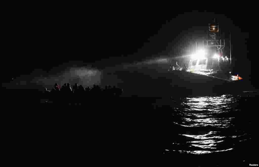 An Italian Guardia Costiera boat arrives to rescue migrants that are on a wooden boat near the island of Lampedusa, in the Mediterranean Sea, Aug. 31, 2021.