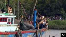 ພວກກູ້ໄພພາກັນຊອກຫາຜູ້ໂດຍສານ ເທິງເຮືອນໍາທ່ຽວລໍານຶ່ງ ທີ່ຫລົ້ມໃນແມ່ນໍ້າໄຊງ່ອນ ໃນແຂວງ Binh Duong, ປະເຫດຫວຽດນາມ, ວັນເສົາ ທີ 21 ພຶດສະພາ 2011. ການສະຫລອງວັນເກີດຂອງເດັກນ້ອຍອາຍຸ 3 ປີຄົນນຶ່ງ ຈົບລົງດ້ວຍໂສກນາດຕະກໍາດັ່ງກ່າວ ທີ່ຍັງຜົນໃຫ້ມີຄົນຕາຍ 15 ຄົນ ເມື່ອວັນສຸກຜ່ານມາ
