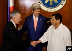Philippine President Rodrigo Duterte, right, greets U.S. Ambassador to the Philippines Philip S. Goldberg, left, as Secretary of State John Kerry looks on during his visit at the Malacanang presidential palace in Manila, Philippines on Wednesday, July 27,