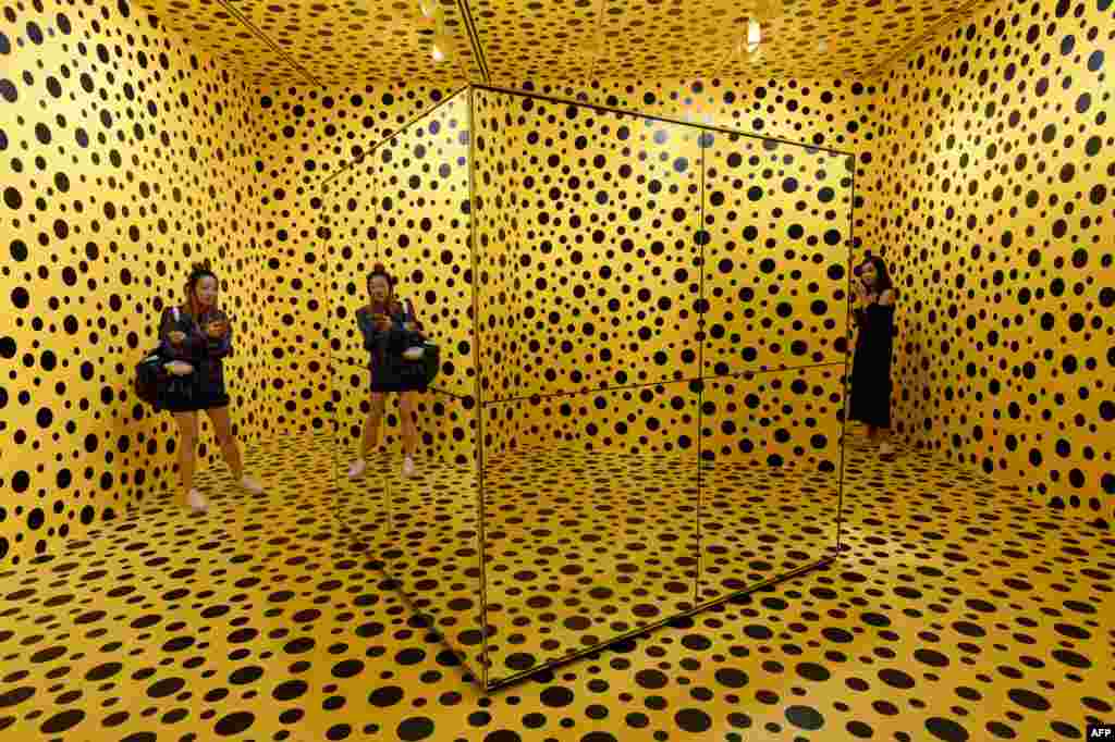 Visitors stand inside an installation by Japanese artist Yayoi Kusuma titled &#39;The Spirits of the Pumpkins Descended into the Heaven&#39; at National Gallery Singapore.
