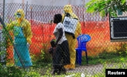 Seorang perempuan dan anaknya tiba untuk pemeriksaan Ebola di fasilitas kesehatan di rumah sakit umum Bwera dekat perbatasan Republik Demokratik Kongo, di Bwera, Uganda, 14 Juni 2019.