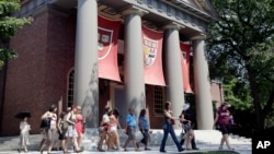 File - A tour group walks through the campus of Harvard University in Cambridge, Massachusetts.