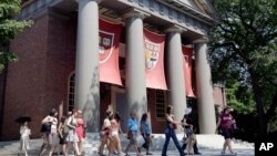 File - A tour group walks through the campus of Harvard University in Cambridge, Massachusetts.