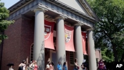 FILE - A tour group walks through the campus of Harvard University in Cambridge, Massachusetts.