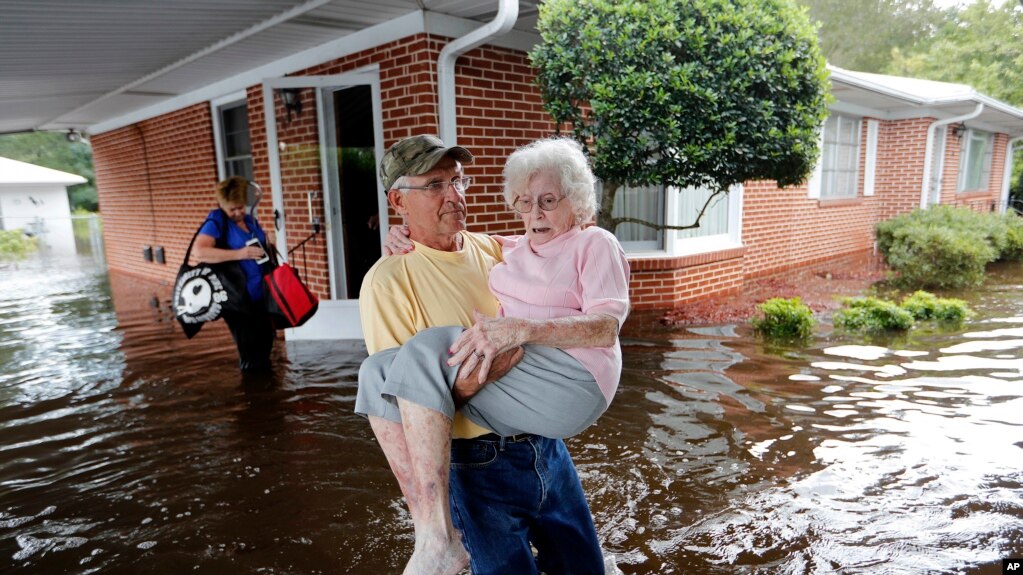 Bob Richling saca a Iris Darden, de 84 aÃ±os, de su casa inundada en Spring Lake, Carolina del Norte, el 17 de septiembre de 2018.