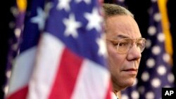 Foto Achiv: Colin Powell gade foul la pandan Prezidan George Bush pwononse yon diskou nan Depatman d'Eta nan Washington, 15 Fev. 2001. 