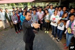 FILE - Cambodian court officer Neth Pheaktra guides students outside the court hall before appeal hearings against two former Khmer Rouge senior leaders, Khieu Samphan and Nuon Chea, at the U.N.-backed war crimes tribunal in Phnom Penh, Cambodia, July 2015.