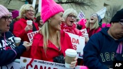 Las mujeres con sombreros rosados comienzan a reunirse temprano y están listas para hacer oír sus voces en el primer día completo de la presidencia de Donald Trump, el 21 de enero de 2017 en Washington.