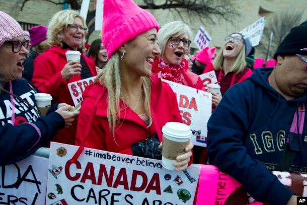 Women with bright pink hats and signs begin to gather early and are set to make their voices heard on the first full day of Donald Trump's presidency, Jan. 21, 2017 in Washington.