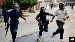 La police anti-émeute pourchasse un manifestant à Bujumbura, au Burundi, le lundi 4 mai 2015. 