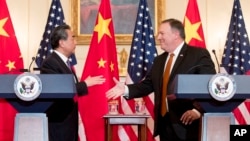 마이크 폼페오 미국 국무장관과 왕이 중국 외교부장이 23일 워싱턴 국무부에서 열린 공동기자회견에서 악수하고 있다.