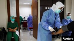 Sejumlah tenaga kesehatan menunggu antrean vaksinasi COVID-19 dengan vaksin Sinovac di sebuah rumah sakit, di Jakarta, 21 Januari 2021. (Foto: Willy Kurniawan/Reuters)