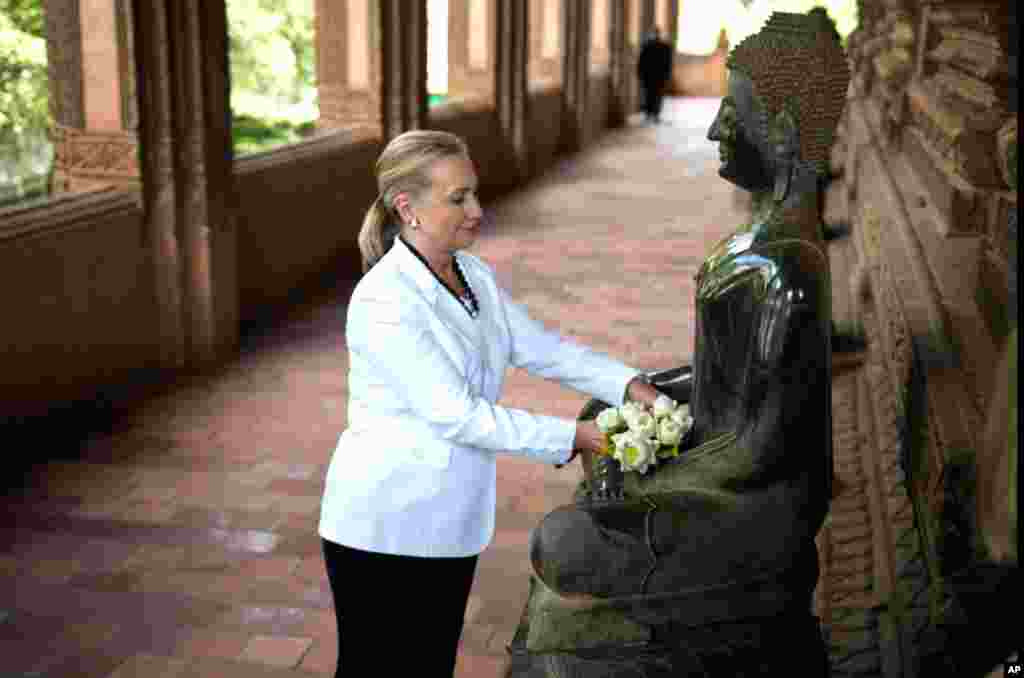 Clinton places flowers at a statue as she toured the Ho Phra Keo Temple, in Vientiane, Laos, July 11.