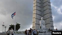 Bendera Kuba dikibarkan setengah tiang di Lapangan Revolusi di Havana hari Minggu (27/11).