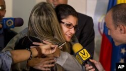 Globovision journalist Nairobi Pinto hugs a colleague as she answers a reporter's question after a press conference following her release from a kidnapping in Caracas, Venezuela, April 14, 2014.