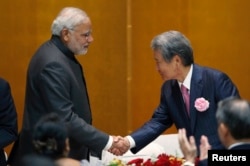 India's Prime Minister Narendra Modi (L) shakes hands with chairman of Japan Business Federation (Keidanren) Sadayuki Sakakibara (R) during a luncheon organized by Keidanren in Tokyo, Sept. 1, 2014.