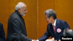 India's Prime Minister Narendra Modi (L) shakes hands with chairman of Japan Business Federation (Keidanren) Sadayuki Sakakibara (R) after Modi spoke during a luncheon organized by Keidanren in Tokyo, September 1, 2014.