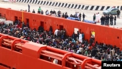 Migrants are seen aboard a navy ship before being disembarked in the Sicilian harbor of Augusta, June 1, 2014.