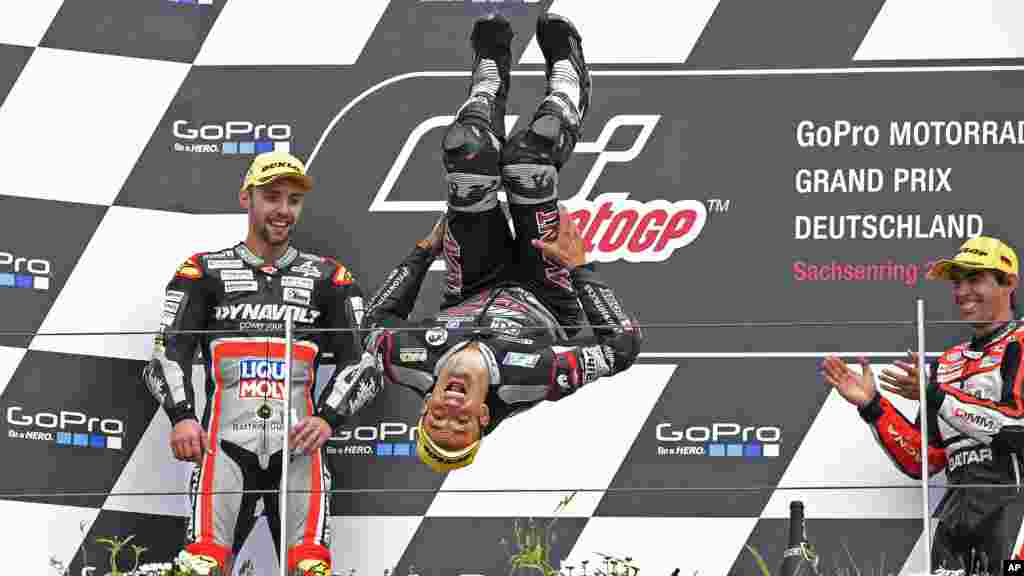 Le pilote français Johann Zarco, fait un backflip lors de la cérémonie de remise de la course, en Allemagne, le 17 juillet 2016.
