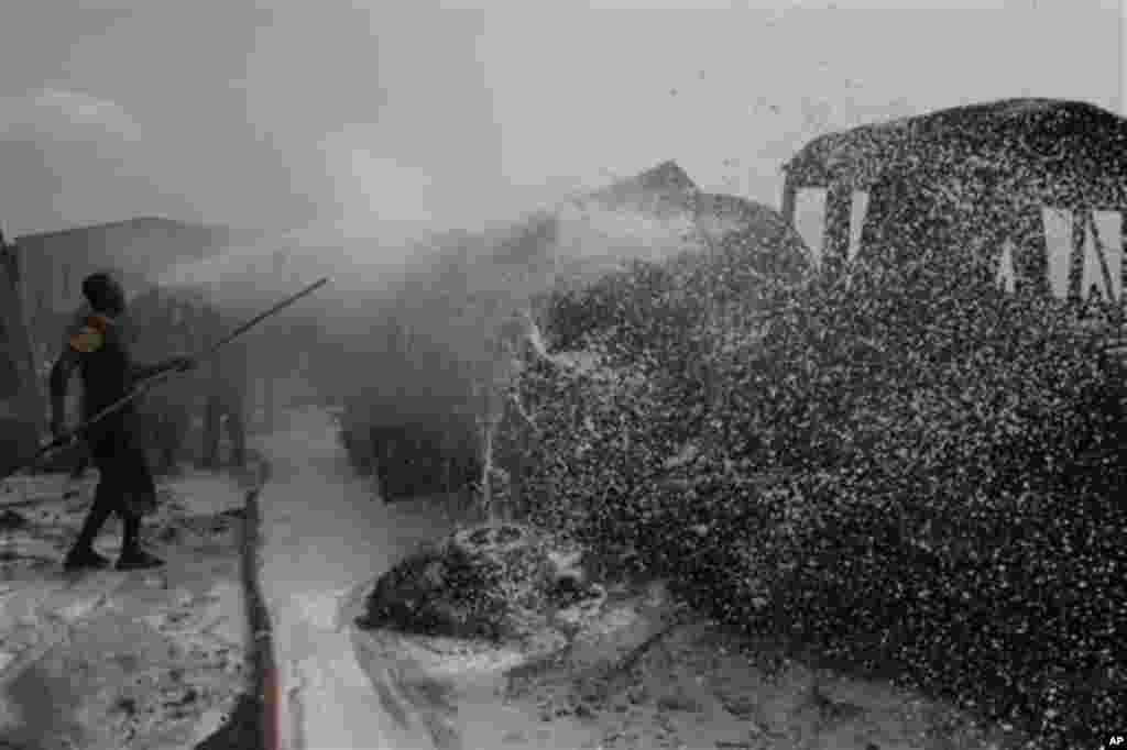 Firefighters try to contain a fire at an informal diesel fuel depot in Lagos, Nigeria on Thursday, Feb. 16, 2012.