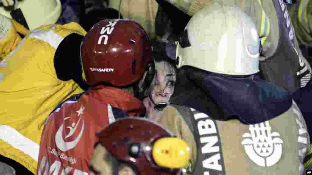 터키 이스탄불의 주거용 건물이 붕괴된 가운데 구조대원들이 잔해 속에 여성을 구조하고 있다.
