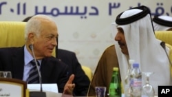Qatar's Prime Minister and Foreign Minister Hamad bin Jassim bin Jabr Al-Thani (R) speaks with Arab League Secretary General Nabil al-Arabi during a meeting of the Committee of Arab Coordination in Doha, December 3, 2011.