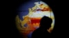 FILE - A woman walks past a map showing the elevation of the sea in the last 22 years during the World Climate Change Conference 2015 (COP21) at Le Bourget, near Paris, France, Dec. 11, 2015. 