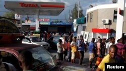 Chofè machin ak motosiklèt ki nan liy pou achte gaz nan Pòtoprens, Ayiti, 7avril 2019. 