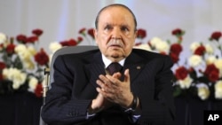 FILE - Algerian President Abdelaziz Bouteflika, sitting in a wheelchair, applauds after taking the oath as president in Algiers, April 28, 2014.