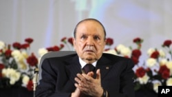 Le président algérien Abdelaziz Bouteflika , assis dans un fauteuil roulant , applaudit après avoir prêté serment en tant que président à Alger , le 28 Avril 2014 (AP Photo/Sidali Djarboub)