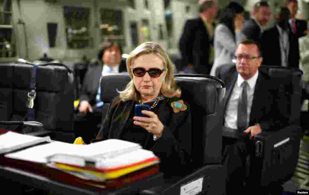 Clinton checks her PDA upon her departure in a military C-17 plane from Malta bound for Tripoli, Libya October 18, 2011. 