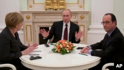 Angela Merkel (à g.), Vladimir Pourtine et François Hollande (à dr) cherchent à forger un accord sur l'Ukraine 