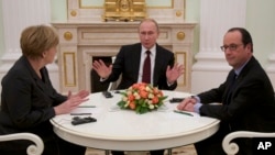 FILE - Russian President Vladimir Putin, center, gestures during his talks with German Chancellor Angela Merkel, left, and French President Francois Hollande, right, in Moscow, Feb. 6, 2015.